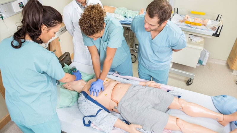 nursing students practicing cpr with a mannequin