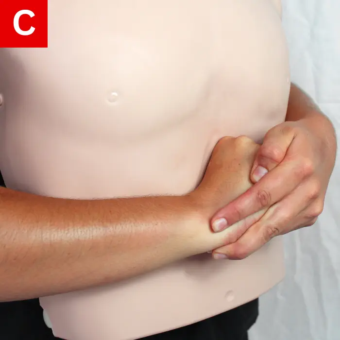 With your other hand, hold the first fist and press forcefully into the abdomen and up toward their chest