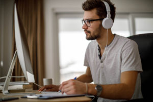 man-infront-of-computer-wearing-headset