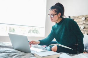 woman-on-bed-infront-of-laptop