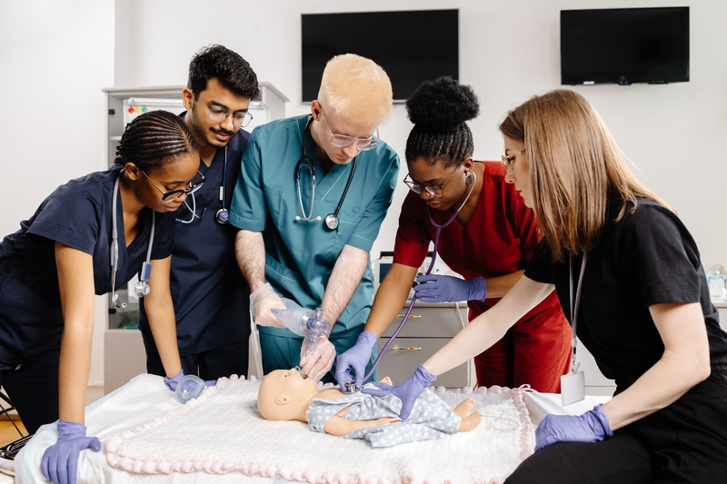 Group of health care professional performing bag mask ventialtion to an infant